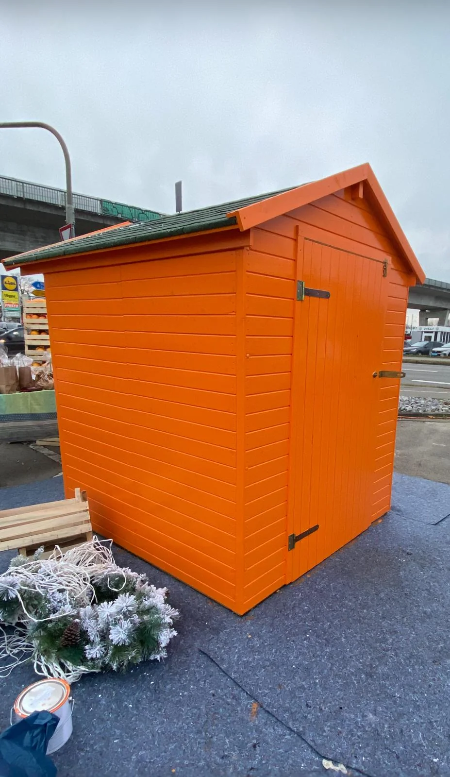 Orange beschichtetes Gartenhaus mit Holztür.